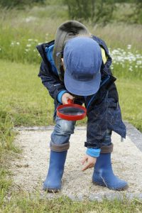 A child explores his backyard using a Storytime at Home kit.